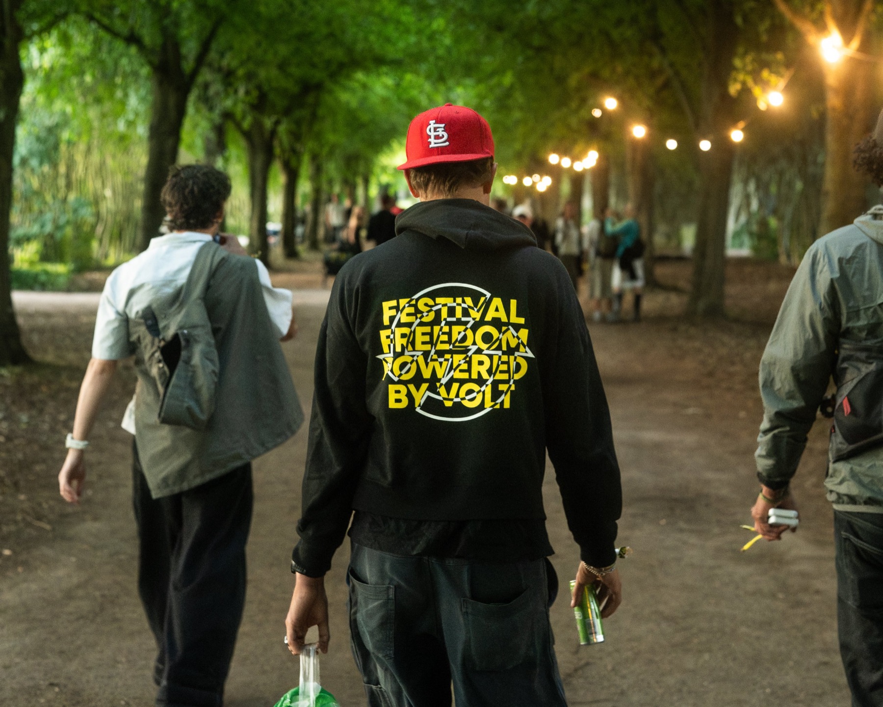 Festival guest in a Volt hoodie reading Festival Freedom Powered by Volt